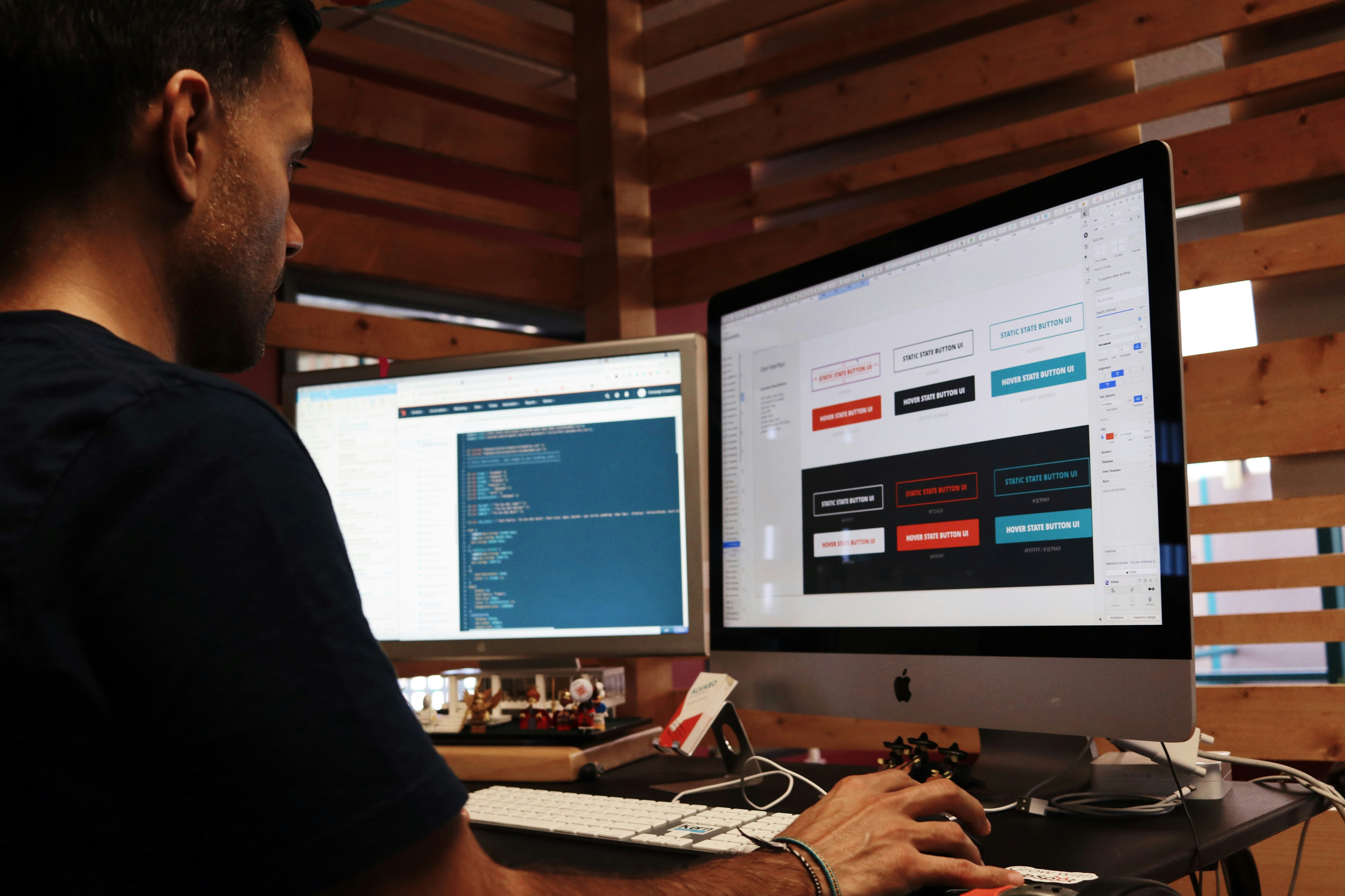 Modern website accessibility features Web designer reviews interface components and button states across two desktop monitors.