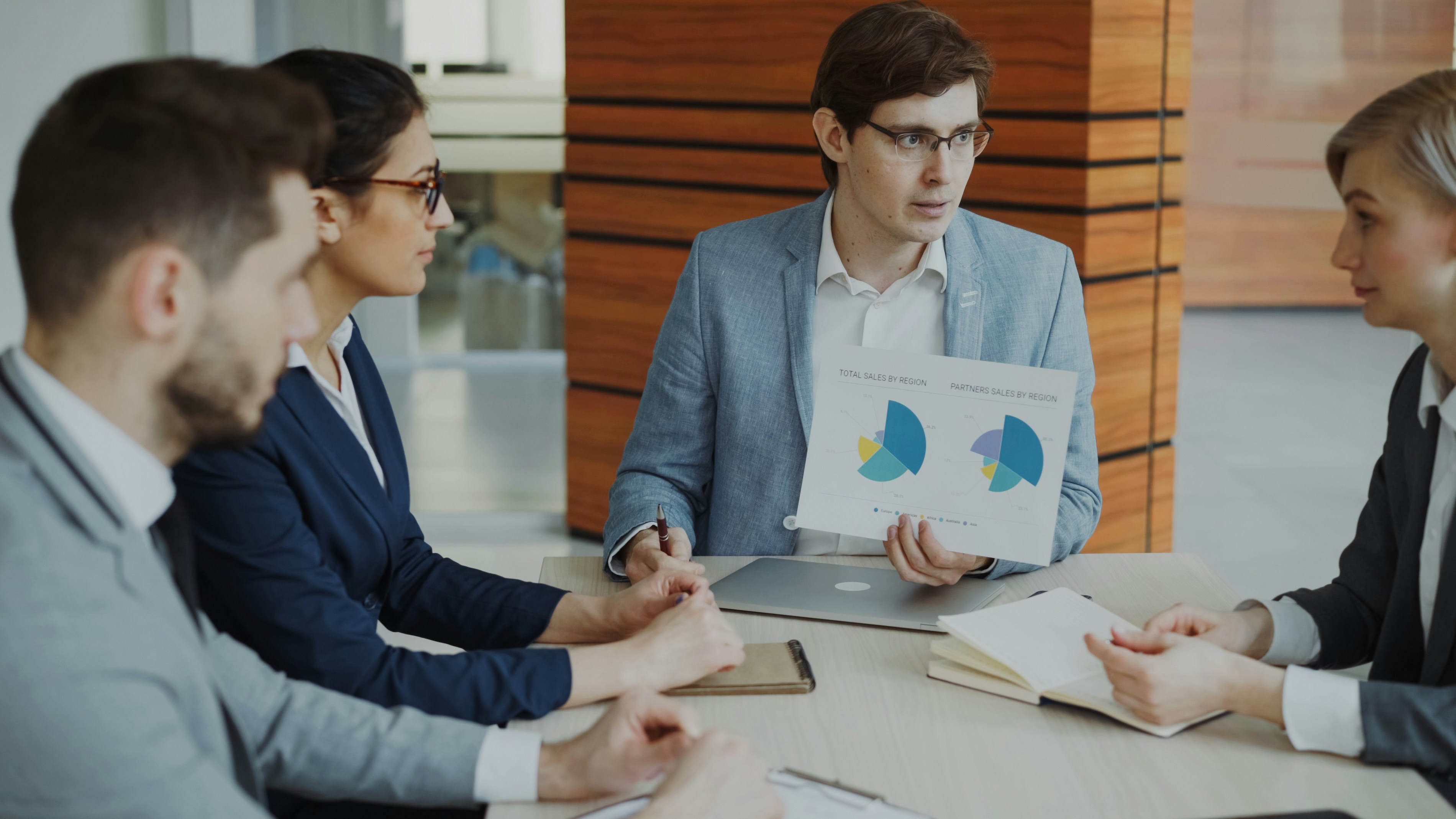 Business team reviews charts and reports during a risk planning meeting.