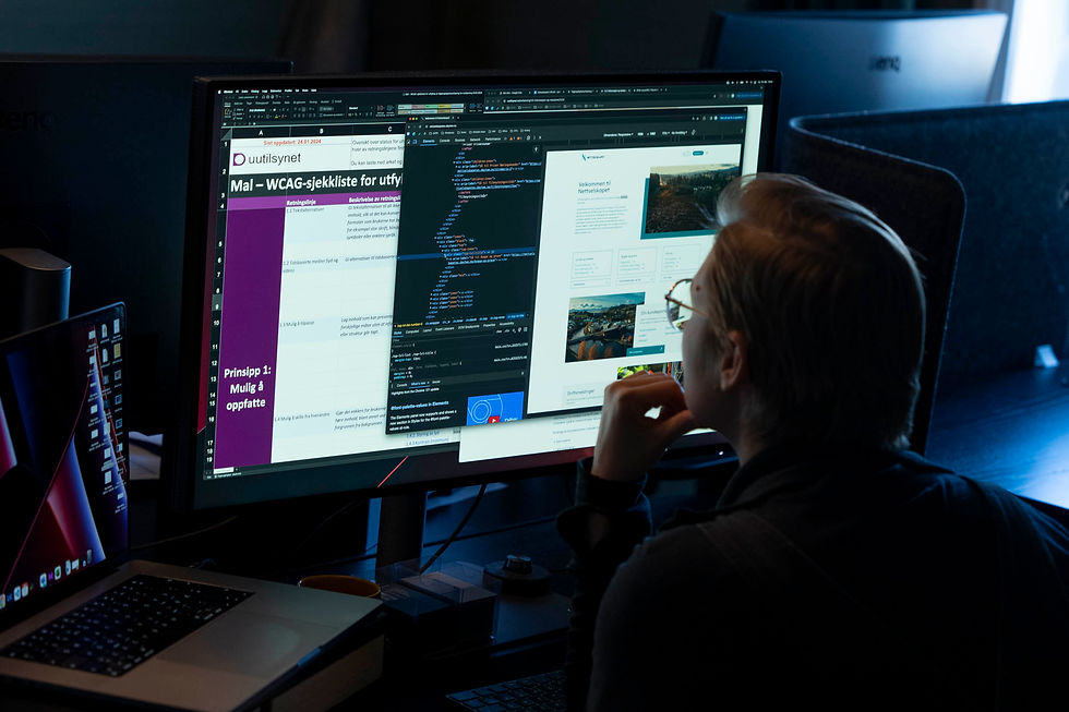 Developer reviews website code and interface behavior on a large desktop monitor.