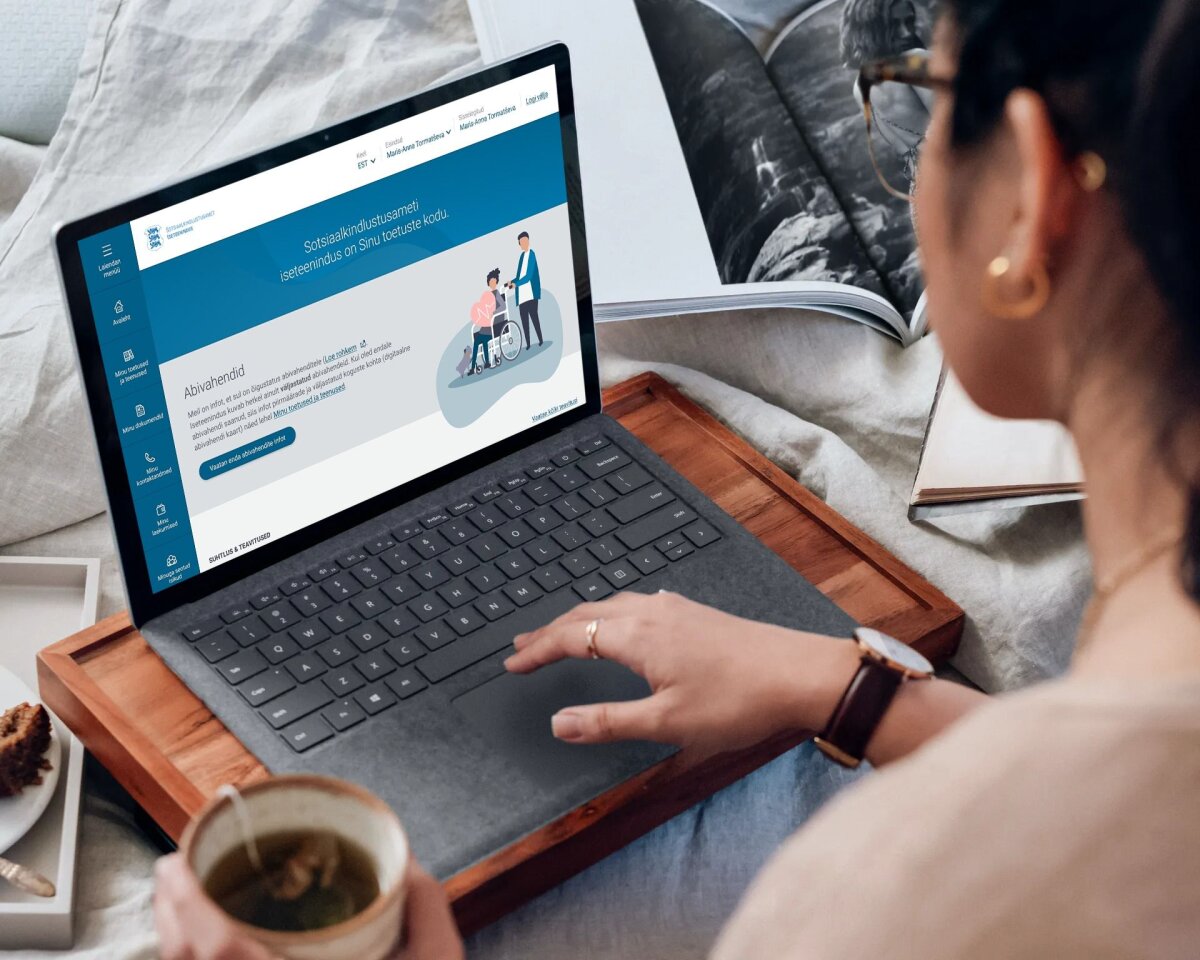 Person uses a public service portal on a laptop from a home workspace.