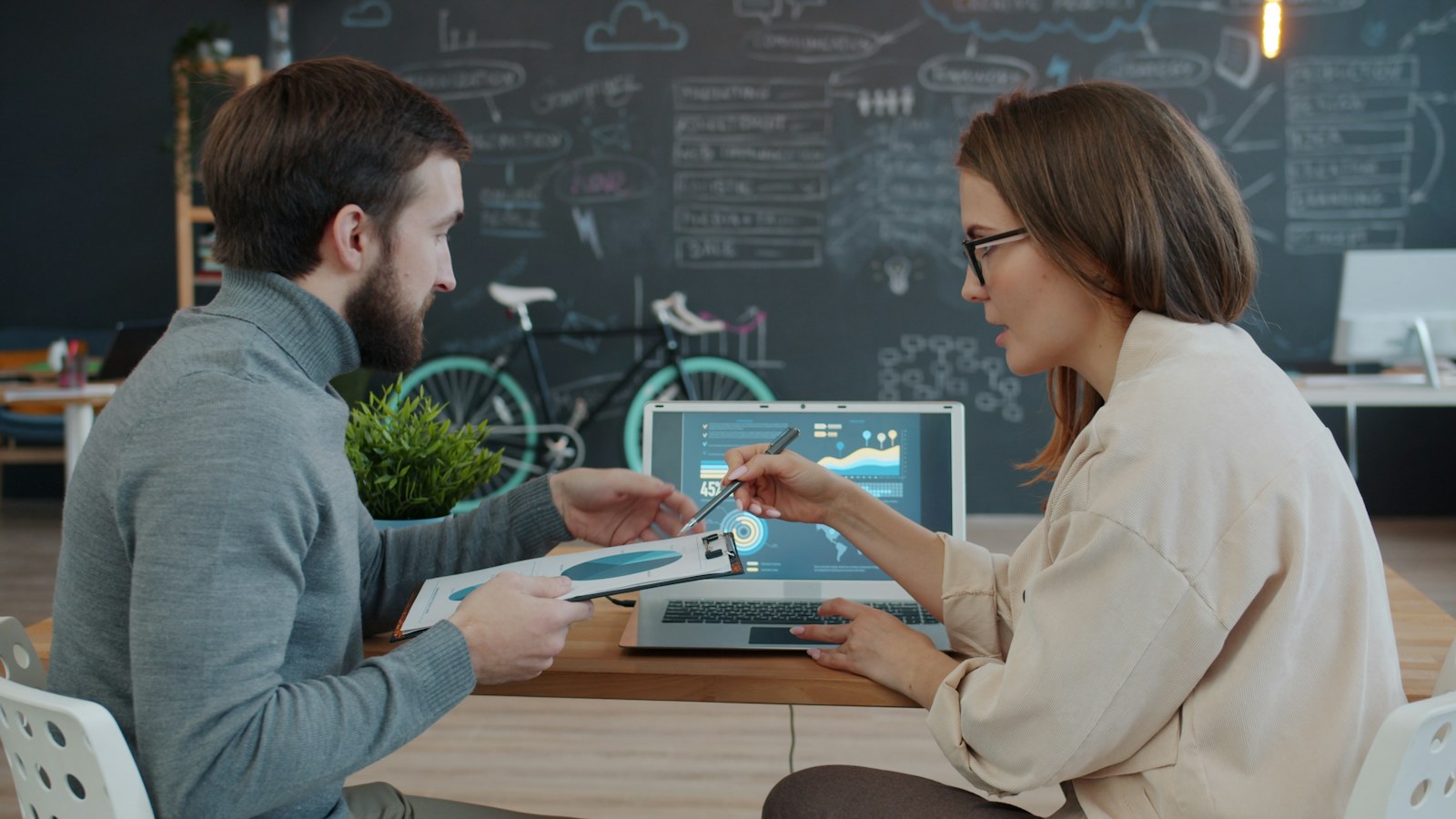 Two colleagues review data and accessibility findings together on a laptop.