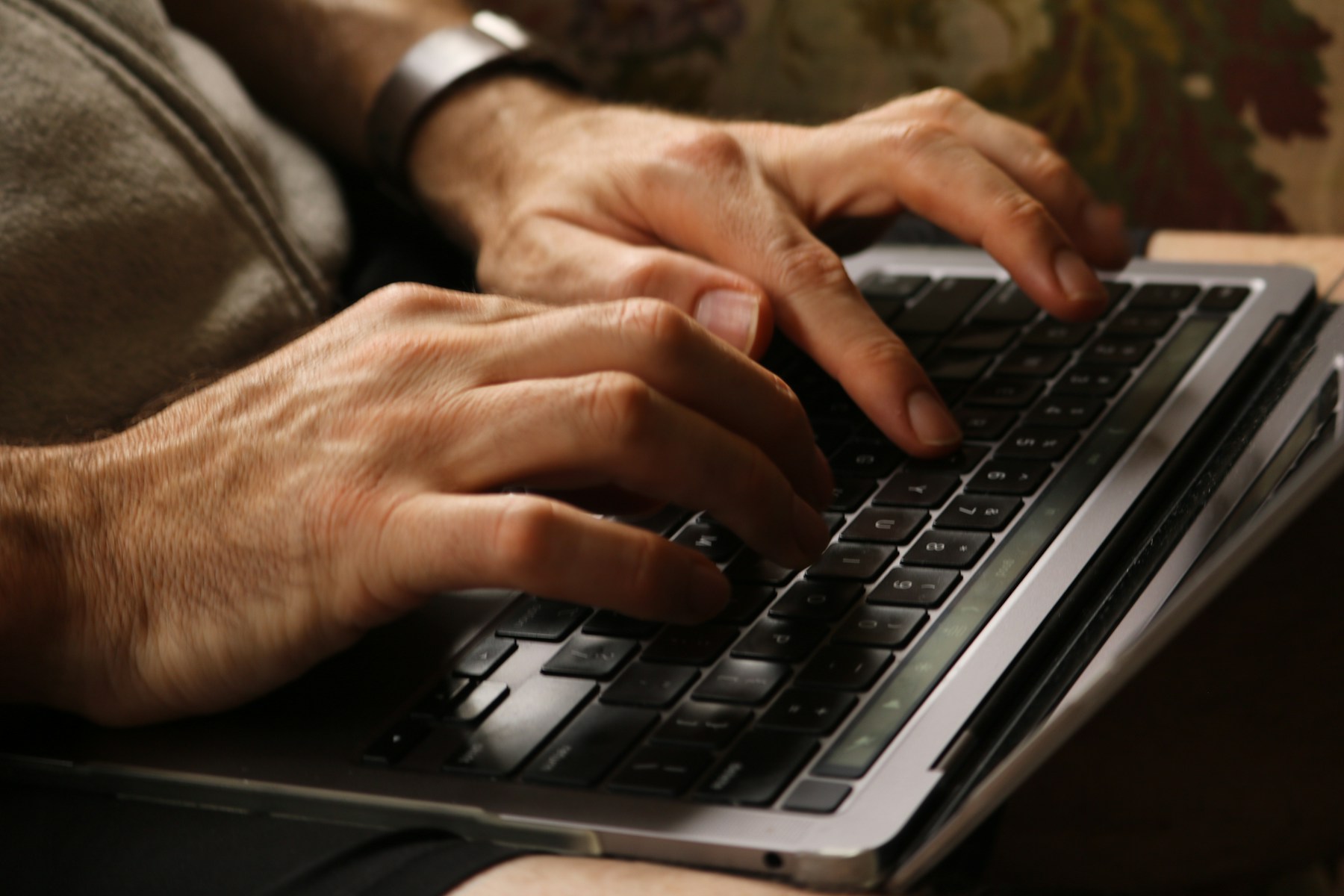Hands use a laptop keyboard while testing a website without a mouse.
