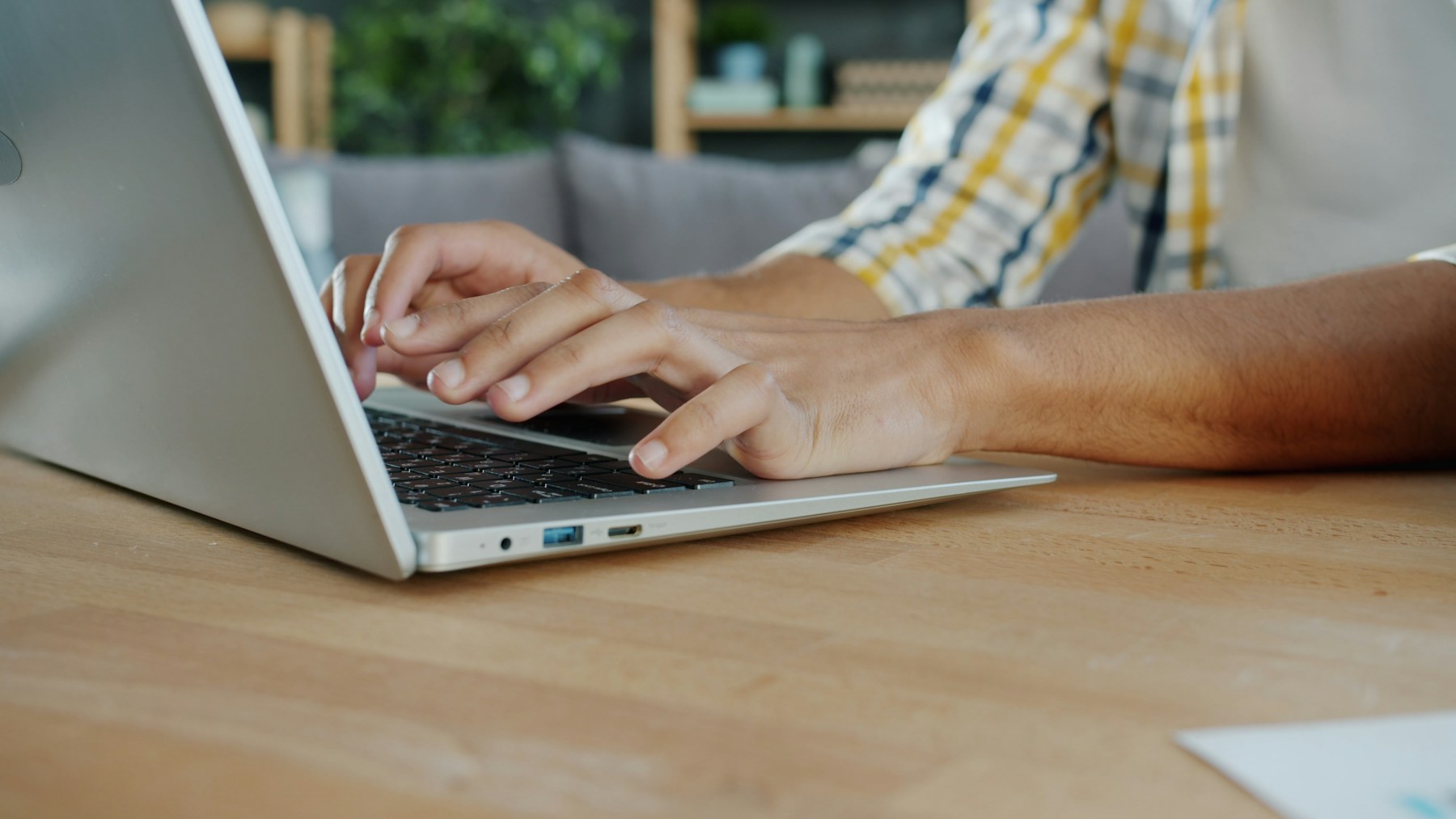 Hands type on a laptop during manual website accessibility testing.